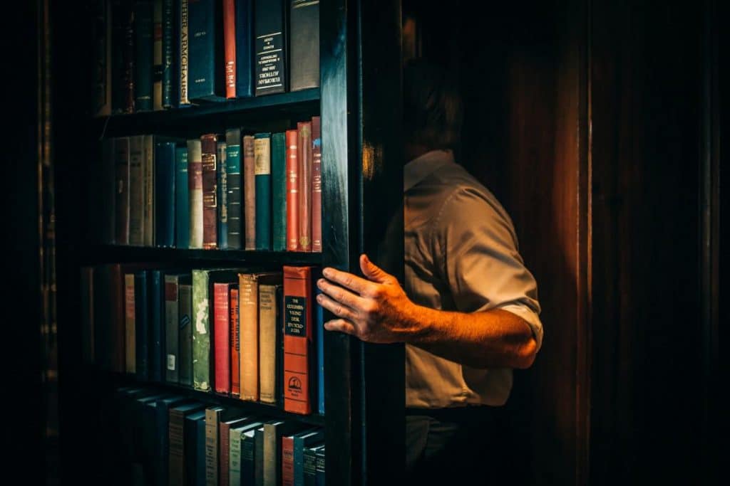 speakeasy hidden bar hidden behind a bookself
